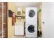 Functional laundry room featuring a stacked washer and dryer, utility sink and ample storage at 1715 S Cholla St, Mesa, AZ 85202
