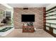 Open concept living room with brick accent wall, built in shelving, and direct view into the kitchen at 1715 S Cholla St, Mesa, AZ 85202