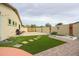 Well-maintained backyard with artificial grass, stepping stones, and garden beds, offering a serene outdoor space at 18550 W Mcneil St, Goodyear, AZ 85338