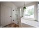 Bathroom featuring a shower, bathtub, and window bringing in natural light at 18550 W Mcneil St, Goodyear, AZ 85338