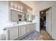 Bright bathroom with double vanity, walk-in closet, and modern lighting fixtures at 18550 W Mcneil St, Goodyear, AZ 85338