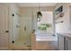 Bright and airy bathroom with glass shower and tub under a window at 18550 W Mcneil St, Goodyear, AZ 85338