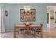 Cozy dining room with a wooden table, six chairs, and a modern chandelier above at 18550 W Mcneil St, Goodyear, AZ 85338