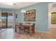 Bright dining area with tile floors, a wooden table, six chairs, and sliding door access to outdoors at 18550 W Mcneil St, Goodyear, AZ 85338