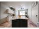 Kitchen island with granite countertop, ceiling fan and tile flooring at 18550 W Mcneil St, Goodyear, AZ 85338