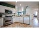 Well-equipped kitchen featuring stainless steel appliances, a stylish range hood, and modern cabinetry at 18550 W Mcneil St, Goodyear, AZ 85338