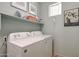 Practical laundry room featuring a washer, dryer, and storage shelving at 18550 W Mcneil St, Goodyear, AZ 85338