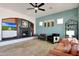 Stylish living room featuring a cozy fireplace, comfortable seating, and a modern ceiling fan at 18550 W Mcneil St, Goodyear, AZ 85338
