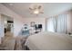 Main bedroom featuring a ceiling fan, carpet, and a view to the kitchen at 18550 W Mcneil St, Goodyear, AZ 85338