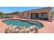 Backyard swimming pool with rock features and a spacious patio, perfect for outdoor relaxation and entertainment at 18550 W Mcneil St, Goodyear, AZ 85338