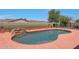 Beautiful in-ground pool with a rock waterfall feature, set against a desert landscape at 18550 W Mcneil St, Goodyear, AZ 85338