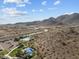 Scenic aerial view showcasing a community pool nestled amidst a mountainous backdrop under a bright blue sky at 21132 W Windsor Ave, Buckeye, AZ 85396