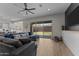Comfortable living room with a large gray sectional, TV, ceiling fan, and sliding door to the backyard at 21132 W Windsor Ave, Buckeye, AZ 85396