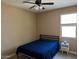 Neutral bedroom featuring a ceiling fan, window, and dark blue bedspread at 21544 W Watkins St, Buckeye, AZ 85326