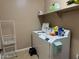 Functional laundry room featuring a washer, dryer, and shelving for storage at 21544 W Watkins St, Buckeye, AZ 85326