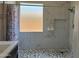 Modern tiled shower with a patterned floor, window, and shower caddy at 21544 W Watkins St, Buckeye, AZ 85326