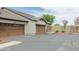 View of a beige home with multi-car garage and neutral landscaping, showcasing its spacious driveway at 2725 E Mine Creek Rd # 1208, Phoenix, AZ 85024