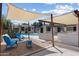 Charming backyard with desert landscaping, blue seating, and a shade structure at 2802 E Mercer Ln, Phoenix, AZ 85028