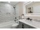 Modern bathroom featuring marble tile, updated fixtures, and a lighted mirror at 2802 E Mercer Ln, Phoenix, AZ 85028