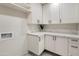 Bright laundry room featuring new white cabinets and countertop at 2802 E Mercer Ln, Phoenix, AZ 85028