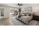 Bright main bedroom with a ceiling fan, sliding glass door access to a private courtyard, and an ensuite bathroom at 2802 E Mercer Ln, Phoenix, AZ 85028