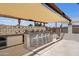 Outdoor kitchen featuring a built-in grill, bar seating, and sun shade at 2802 E Mercer Ln, Phoenix, AZ 85028