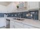 Close up of sink with stainless steel appliances and blue backsplash complete with white countertops at 29891 N Desert Angel Dr, San Tan Valley, AZ 85143
