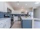 Well-equipped kitchen boasts stainless steel appliances, blue backsplash, an island, and sleek white cabinets at 29891 N Desert Angel Dr, San Tan Valley, AZ 85143