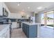 Modern kitchen with stainless steel appliances, blue tiled backsplash, an island with a marble countertop, and a sliding glass door at 29891 N Desert Angel Dr, San Tan Valley, AZ 85143