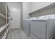 Convenient laundry room is complete with shelving for storage and a washer and dryer at 29891 N Desert Angel Dr, San Tan Valley, AZ 85143