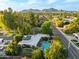 Aerial view of backyard featuring a sparkling blue swimming pool, lush greenery and mountain backdrop at 301 W Royal Palm Rd, Phoenix, AZ 85021