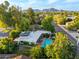 Aerial view of backyard featuring a sparkling blue swimming pool, lush greenery and mountain backdrop at 301 W Royal Palm Rd, Phoenix, AZ 85021