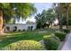 Backyard landscaping featuring healthy green lawn, mature trees, flowering plants, and trimmed shrubs at 301 W Royal Palm Rd, Phoenix, AZ 85021
