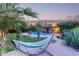 Inviting backyard featuring a pool, hammock, mature landscaping, and charming brick patio for relaxing and outdoor enjoyment at 301 W Royal Palm Rd, Phoenix, AZ 85021