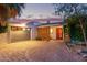 Mid-century home featuring circular driveway, a gray garage door, and an orange front door at 301 W Royal Palm Rd, Phoenix, AZ 85021