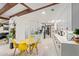 Open-concept kitchen features modern white cabinets, a tiled backsplash, and a cozy breakfast nook with bright yellow chairs at 301 W Royal Palm Rd, Phoenix, AZ 85021