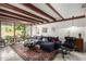 Cozy living room with exposed wood beams, large sectional, eclectic decor, and abundance of natural light at 301 W Royal Palm Rd, Phoenix, AZ 85021