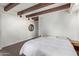 Spacious bedroom features exposed wooden beams, neutral walls, modern lighting, and hardwood floors at 301 W Royal Palm Rd, Phoenix, AZ 85021