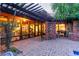 Covered outdoor patio with brick pavers, wood beams, and lush greenery at 301 W Royal Palm Rd, Phoenix, AZ 85021