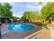 Backyard pool with brick surround, poolside bar, and mature trees offers a perfect backyard retreat at 301 W Royal Palm Rd, Phoenix, AZ 85021