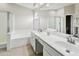 A well lit bathroom with dual sinks, granite countertops, and a glass shower and soaking tub at 3126 W Stephens Pl, Chandler, AZ 85226
