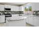 Bright kitchen features white cabinets, granite counters, stainless steel appliances, and stylish mosaic backsplash at 3126 W Stephens Pl, Chandler, AZ 85226