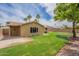 A well-maintained backyard featuring a lush lawn, mature trees, and sprinkler system at 3620 E Ludlow Dr, Phoenix, AZ 85032