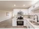 New kitchen featuring white cabinets, stainless steel appliances, a subway backsplash, and light stone countertops at 3620 E Ludlow Dr, Phoenix, AZ 85032
