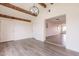 Open living room with neutral paint, light wood-look flooring, and wooden beams on the ceiling at 3620 E Ludlow Dr, Phoenix, AZ 85032