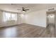 Open living room with wood-look floors, a ceiling fan, a front window and fresh white paint at 3620 E Ludlow Dr, Phoenix, AZ 85032