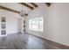 Living room featuring gray wood floors, a vaulted ceiling with wood beams, built-in shelves, and a big window at 3620 E Ludlow Dr, Phoenix, AZ 85032