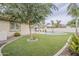 Lush backyard boasts artificial turf, a pool with a water feature, and mature landscaping for outdoor enjoyment at 4067 S White Dr, Chandler, AZ 85249