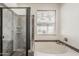Bathroom featuring a glass shower and a soaking tub with decorative tiling and a window at 4067 S White Dr, Chandler, AZ 85249