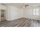 Spacious bedroom with wood-look flooring, a ceiling fan, and a view to the hallway at 4067 S White Dr, Chandler, AZ 85249